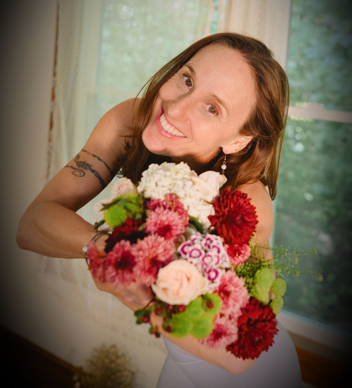 Raphaela Fritz smiling and holding a bouquet of dahlias and roses
